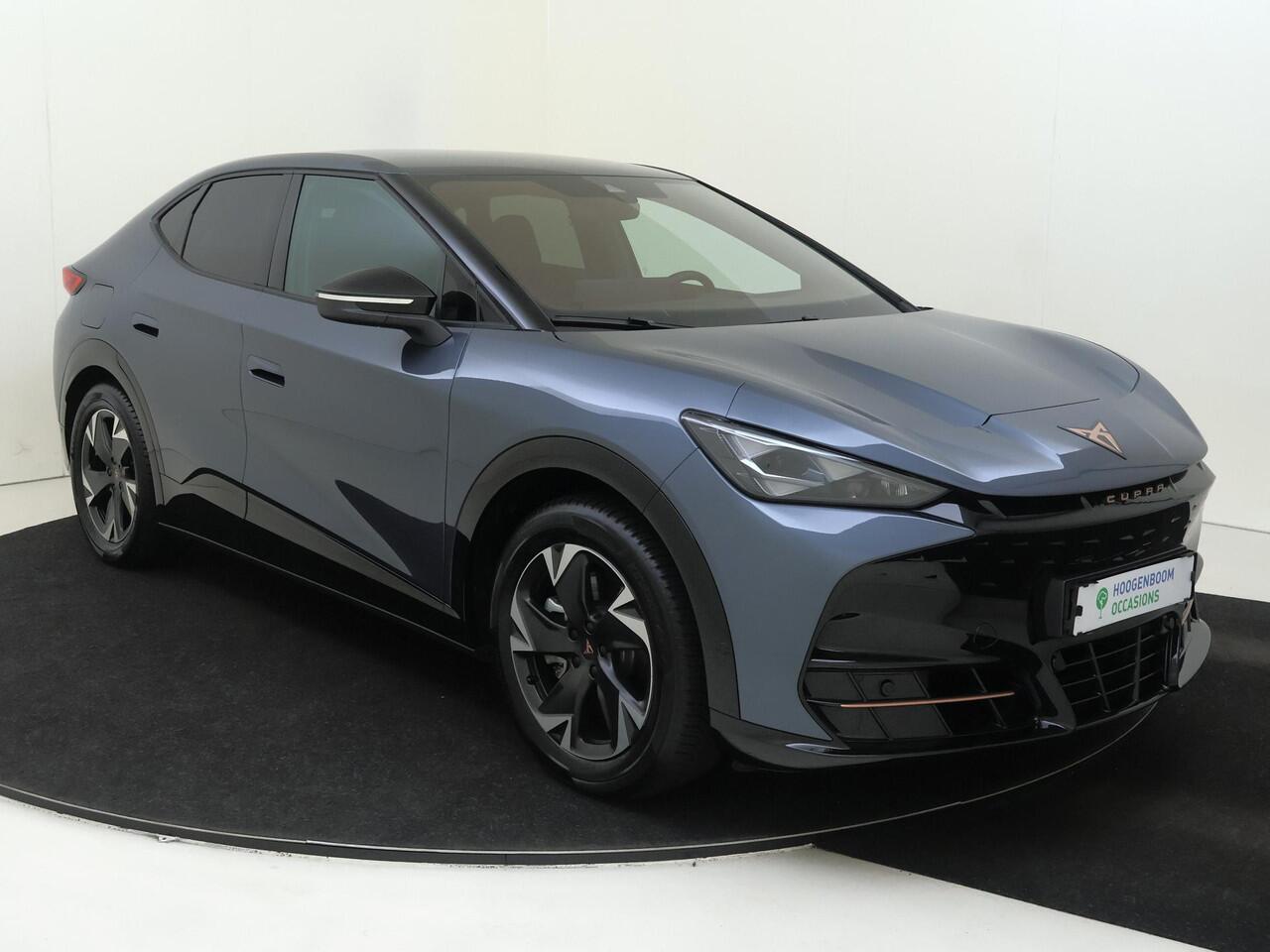 Cupra Tavascan Business 82 kWh | SoH 100% | Trekhaak | Achteruitrijcamera | 3-zone airco | Dodehoek detectie | Keyless | Adaptieve cruise control | CarPlay | Stoel- en stuurwielverwarming |