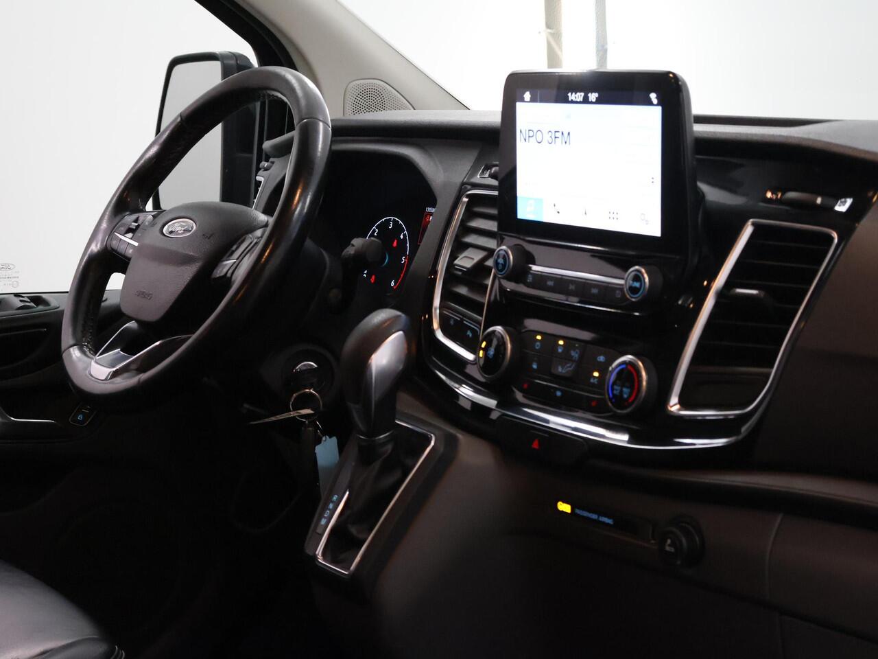 Ford TRANSIT CUSTOM 300 2.0 TDCI | L2 H1 | LIMITED | DUBBEL CABINE | AUT. | LEDEREN BEKLEDING | CAMERA | ADAPTIEVE CRUISE | STOELVERWARMING | NAVIGATIE | BI-XENON | 2X ZIJSCHUIFDEUR | AGATE BLACK METALLIC