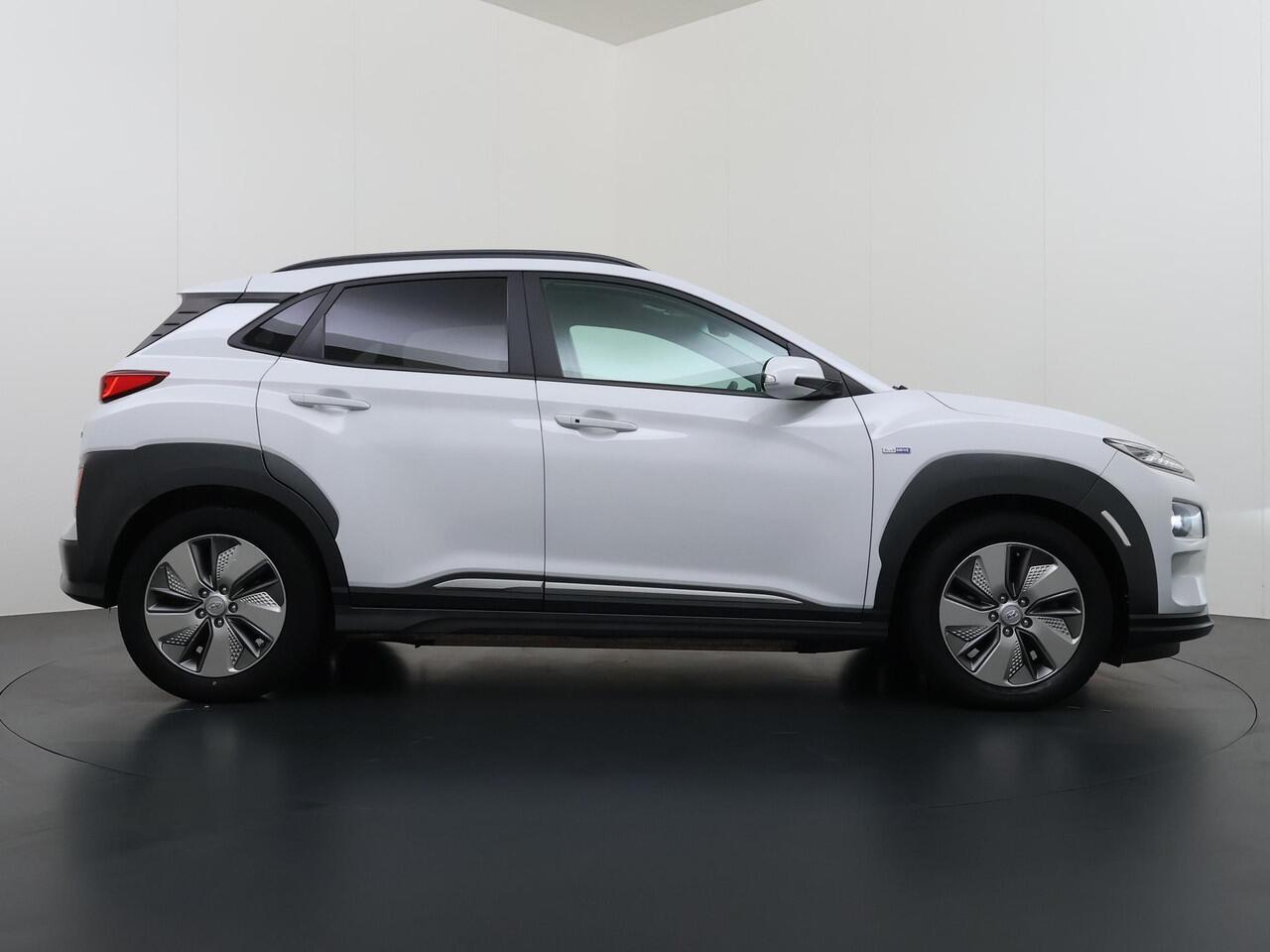 Hyundai Kona EV Premium 64 kWh VAN ¤ 20.900 ,- VOOR ¤ 17.877,- UW LENTEVOORDEEL ¤ 3.023,-! | SOH 100% | 3-FASE | WARMTEPOMP | LEDER | STOEL VERWARM, VENTILATIE | CAMERA | RIJKLAAR INCL. 12 MND BOVAG GARANTIE