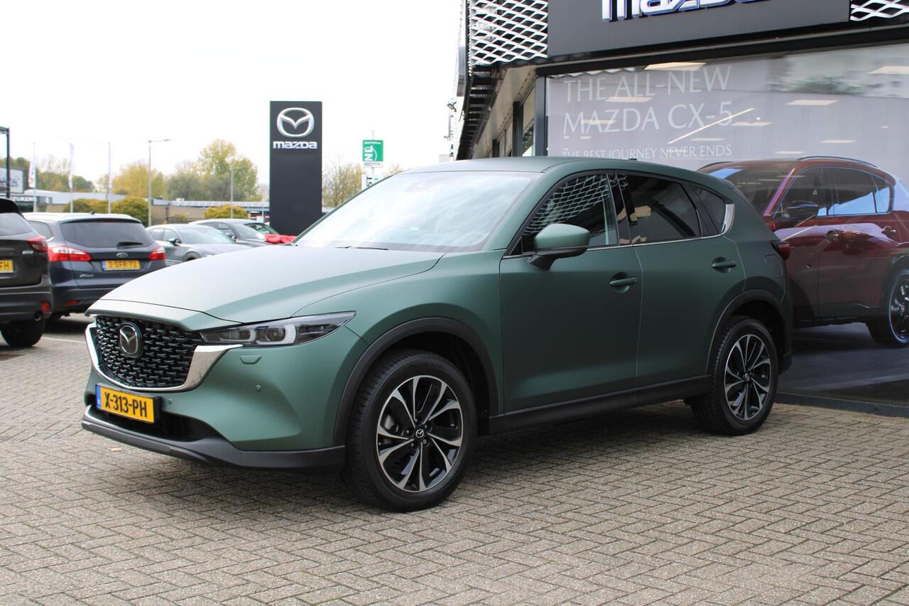 Mazda CX-5 2.0 e-SkyActiv-G M Hybrid 165 Exclusive-Line+Com.P , Automaat, Matte Metallic Pine Green gewrapped, Black Comfort Pack, Navi, Adap.Cruise, Clima, Apple Carplay, 360 Camera, PDC, HUD, Stuur/Stoelverwarming, 19" LMV