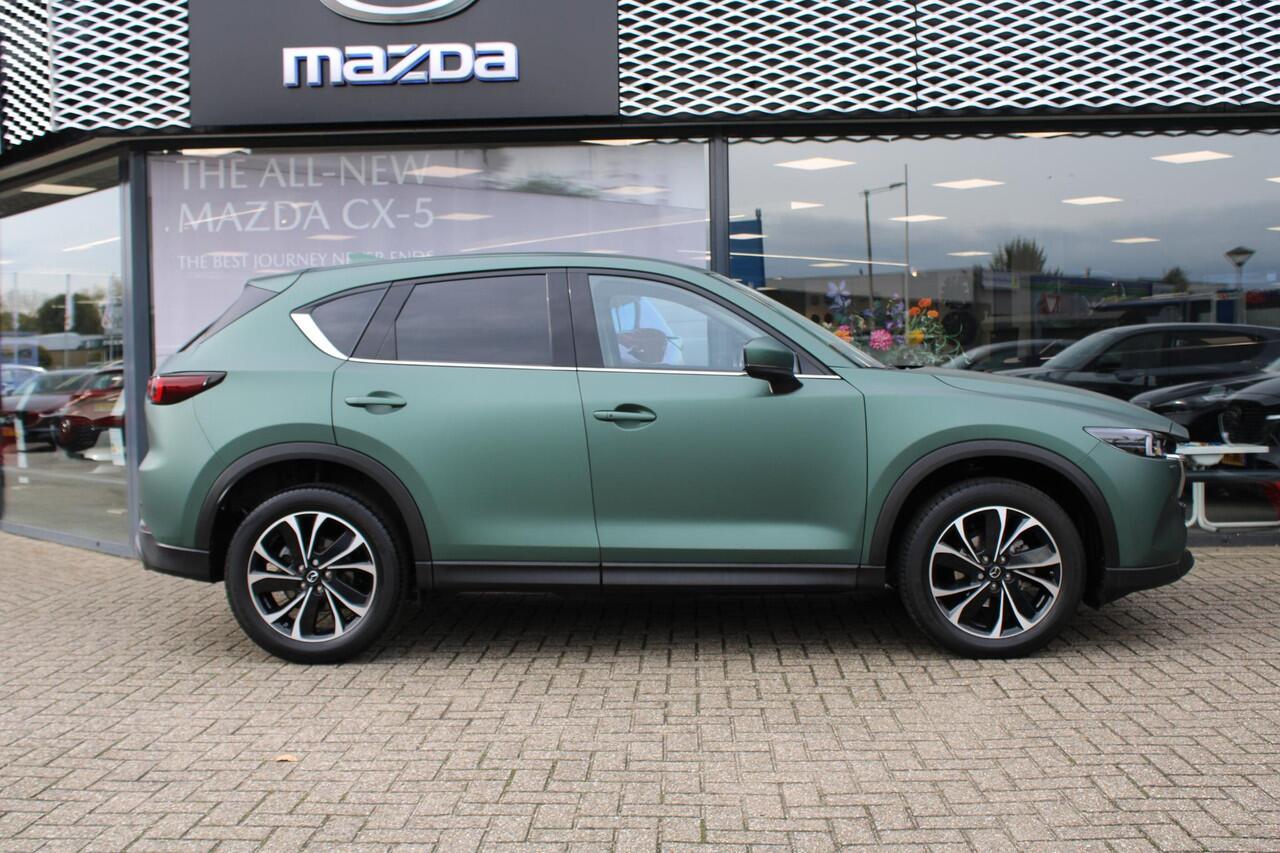 Mazda CX-5 2.0 e-SkyActiv-G M Hybrid 165 Exclusive-Line+Com.P , Automaat, Matte Metallic Pine Green gewrapped, Black Comfort Pack, Navi, Adap.Cruise, Clima, Apple Carplay, 360 Camera, PDC, HUD, Stuur/Stoelverwarming, 19" LMV