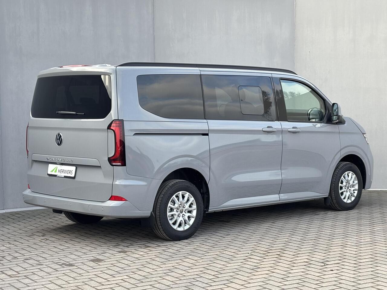 Volkswagen E-Transporter Caravelle 32 L1H1 Life 64 kWh Automaat / NIEUW/ Fabrieksgarantie tot 12-2027 / 8 Persoons / WLTP 305 km / Stone Gray / Warmtepomp / Apple Carplay/Android Auto / Licht en zicht-pakket / Keyless entry / draadloze telefoonlader /