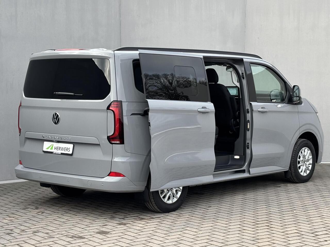Volkswagen E-Transporter Caravelle 32 L1H1 Life 64 kWh Automaat / NIEUW/ Fabrieksgarantie tot 12-2027 / 8 Persoons / WLTP 305 km / Stone Gray / Warmtepomp / Apple Carplay/Android Auto / Licht en zicht-pakket / Keyless entry / draadloze telefoonlader /